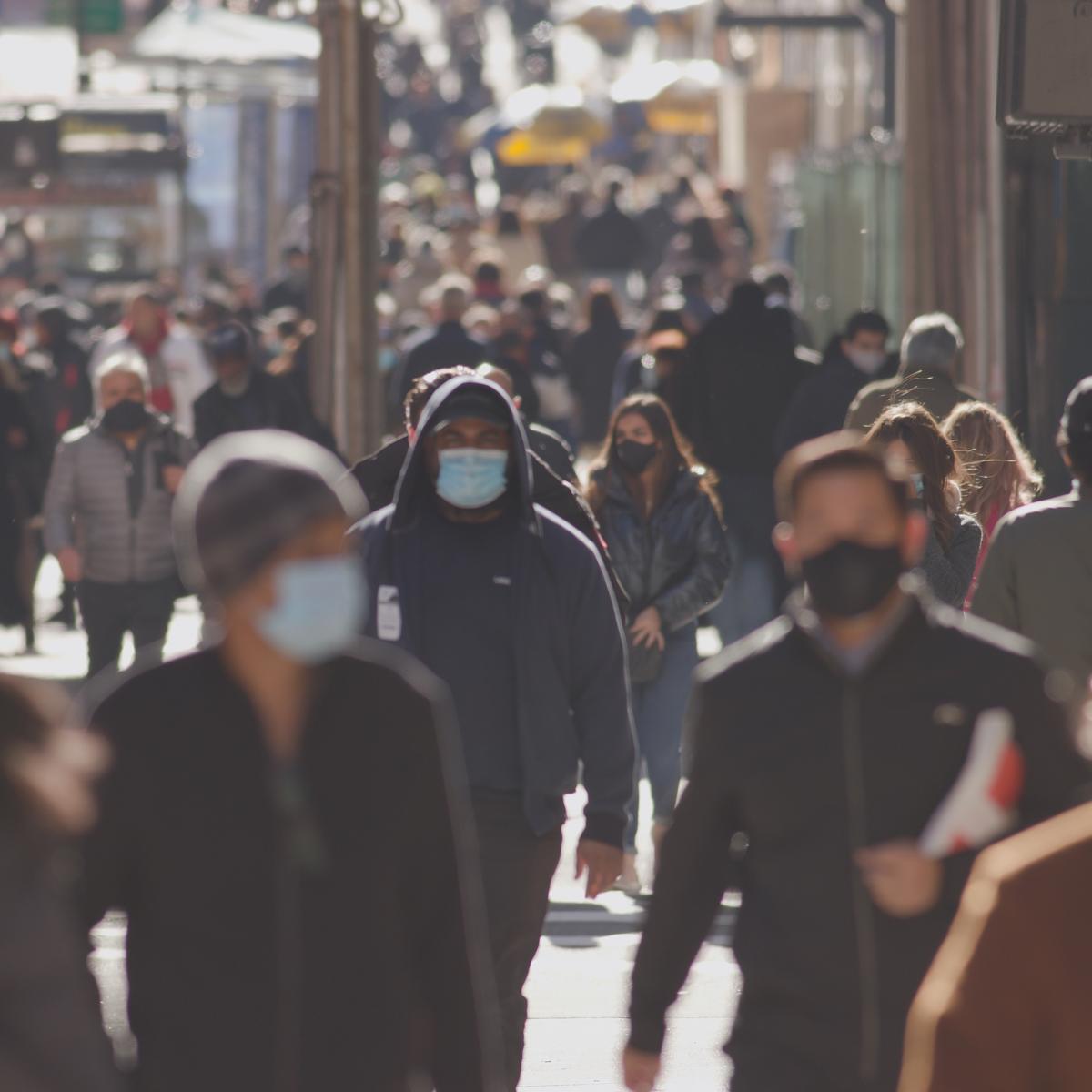 Menschen auf der Strasse tragen Schutzmasken.