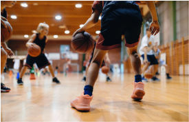 Knaben spielen Basketball in der Turnhalle