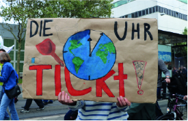 Demonstrantin hält ein Klimastreik-Plakat